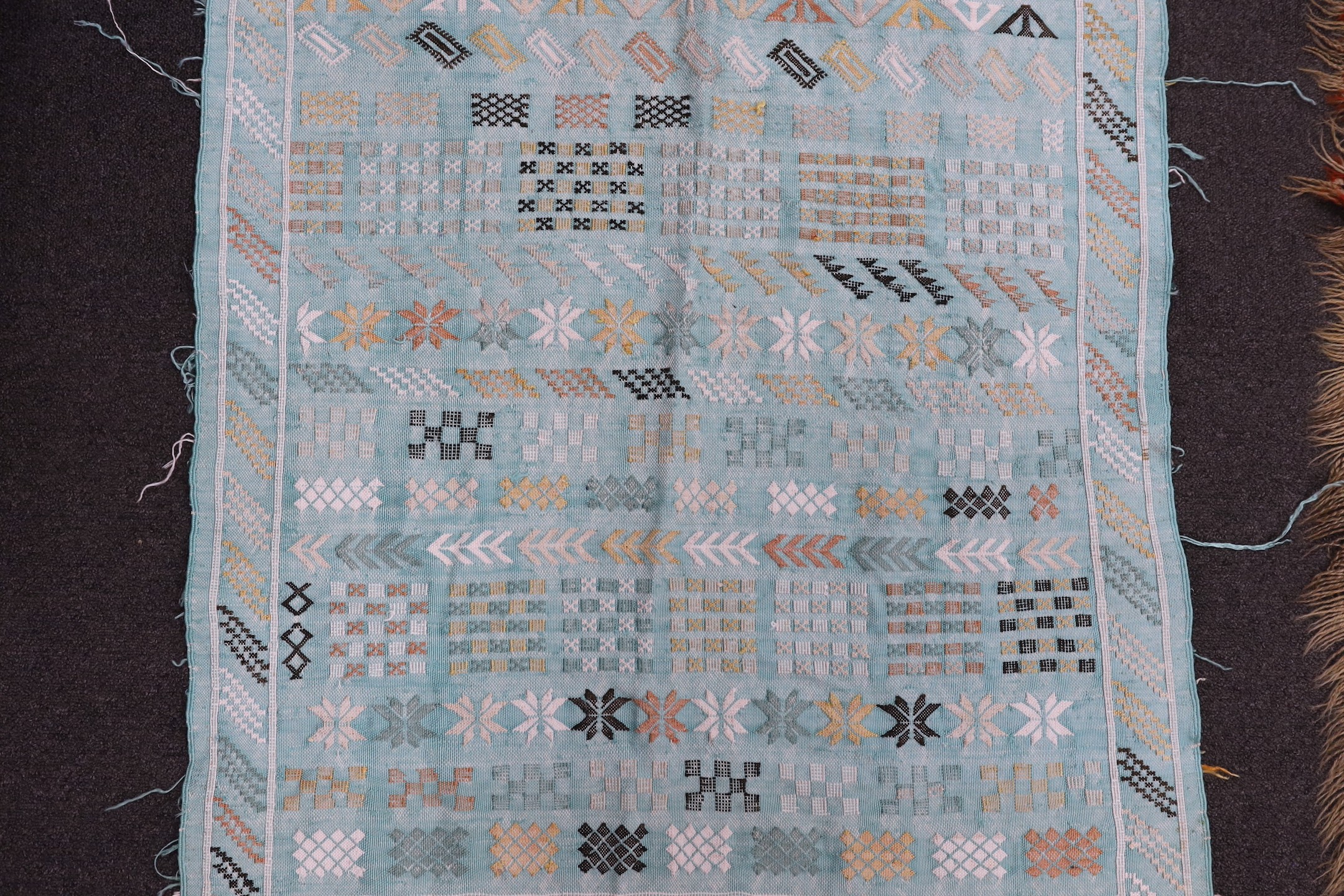 A turquoise rug, possibly Scandinavian